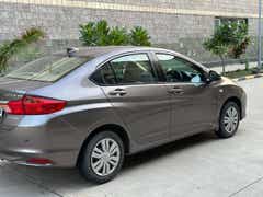 rear three-quarter of a Honda City in a residential area