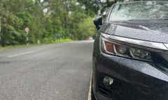 front headlight close-up of a Honda City on a wet road