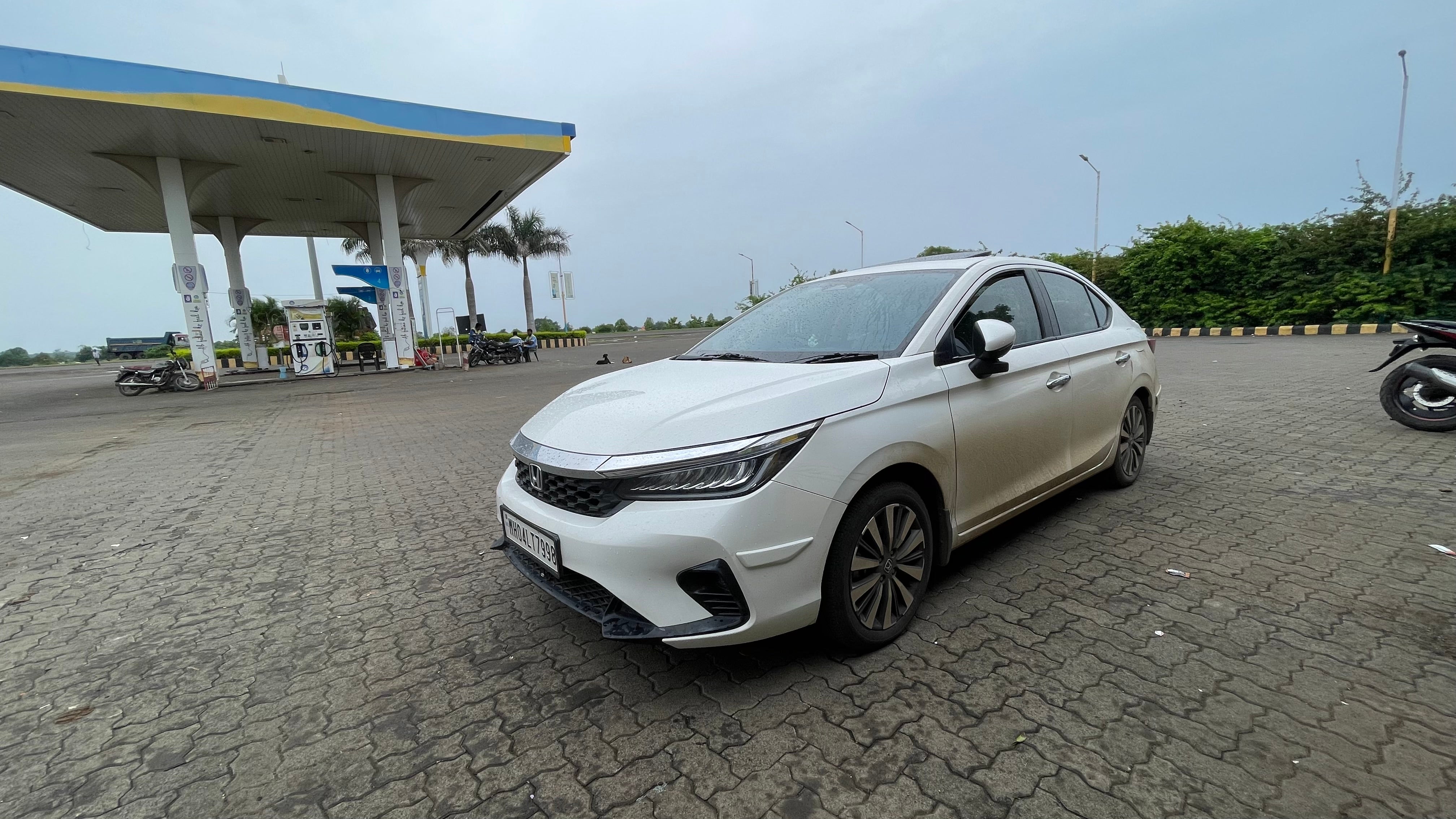 front three-quarter view of a Honda City at a petrol station