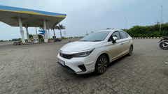 front three-quarter view of a Honda City at a petrol station