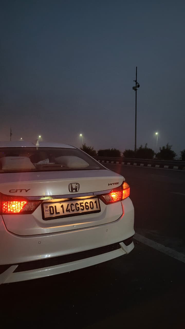 rear view of a Honda City on a city road at dusk