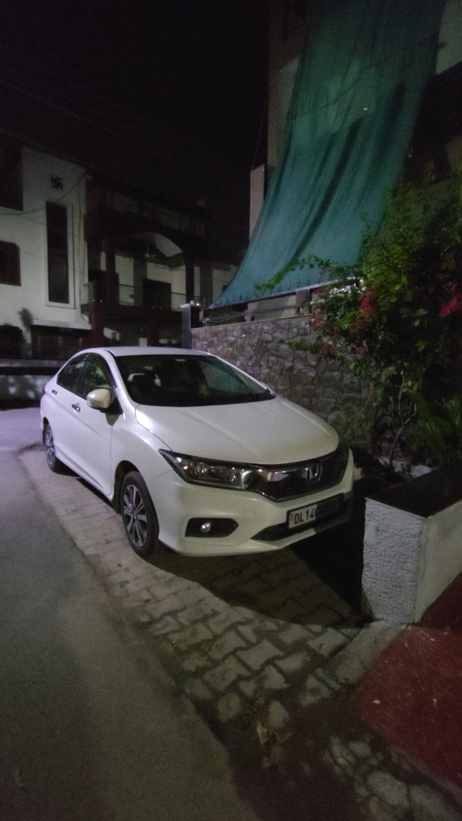 Front three-quarter view of a Honda City parked on a street at night