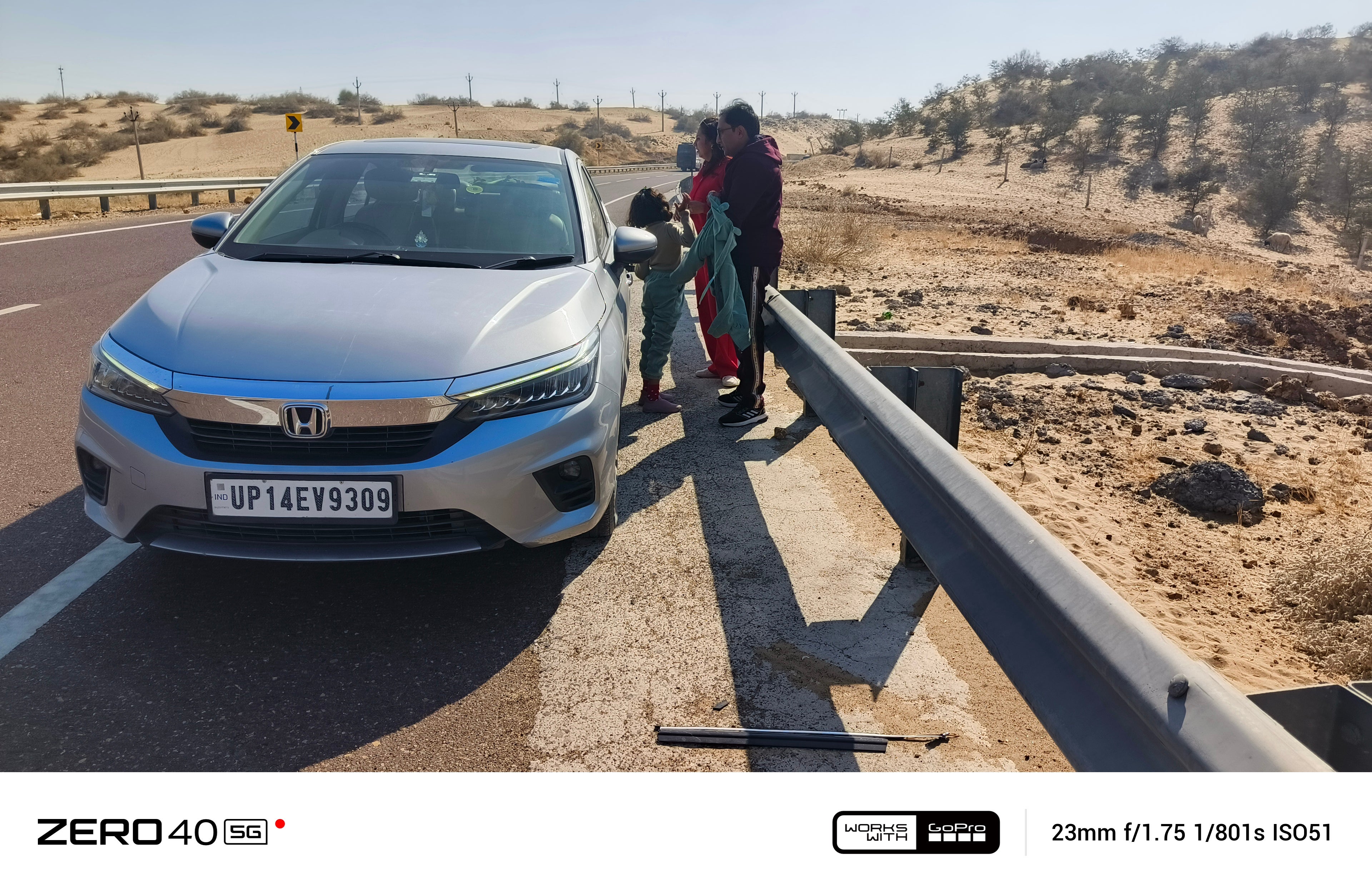 front view of a Honda City near a road barrier