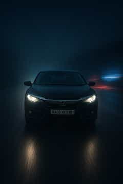 Front view of a Honda City on a wet road at night