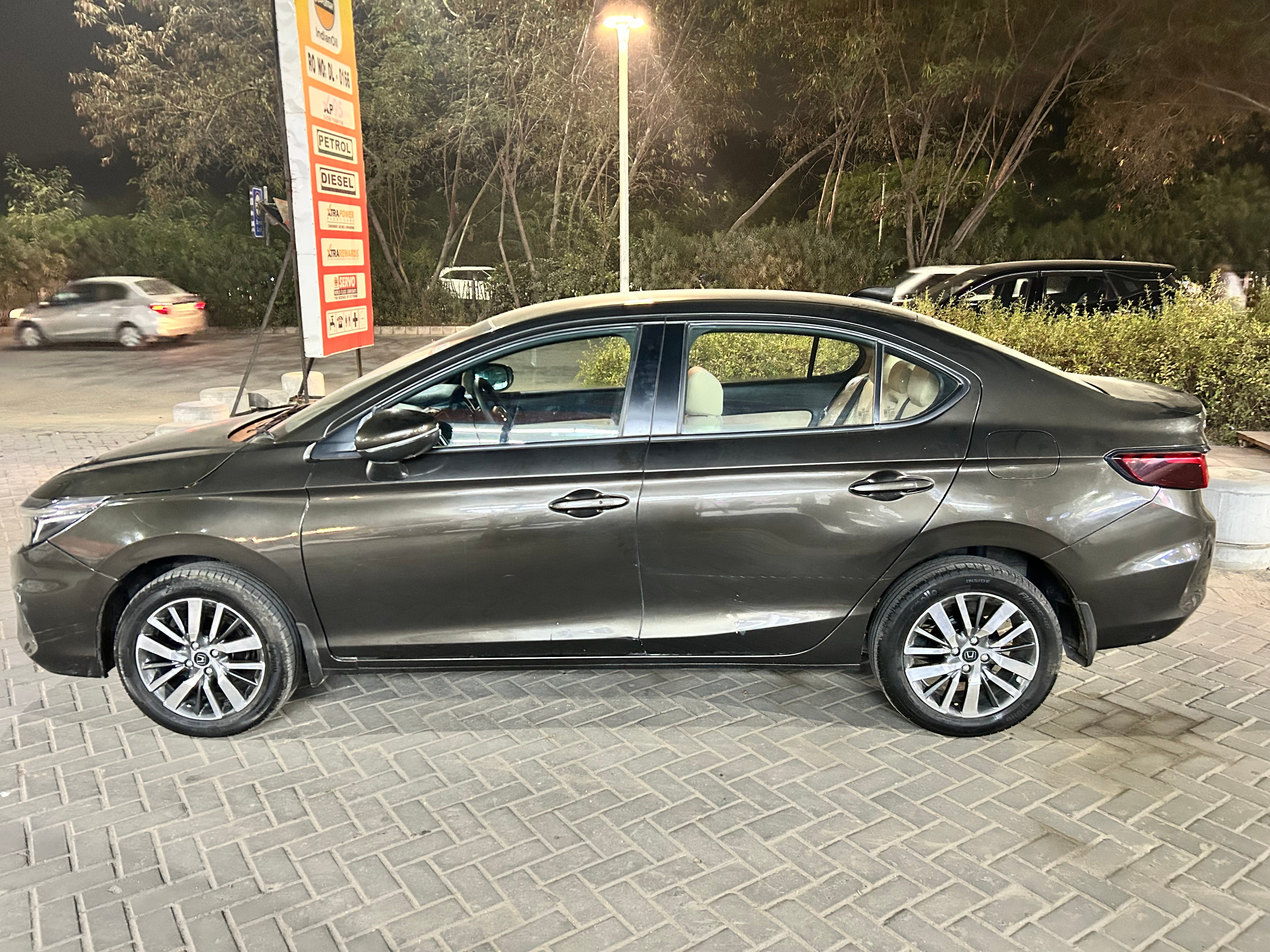 side view of a Honda City sedan at a petrol station