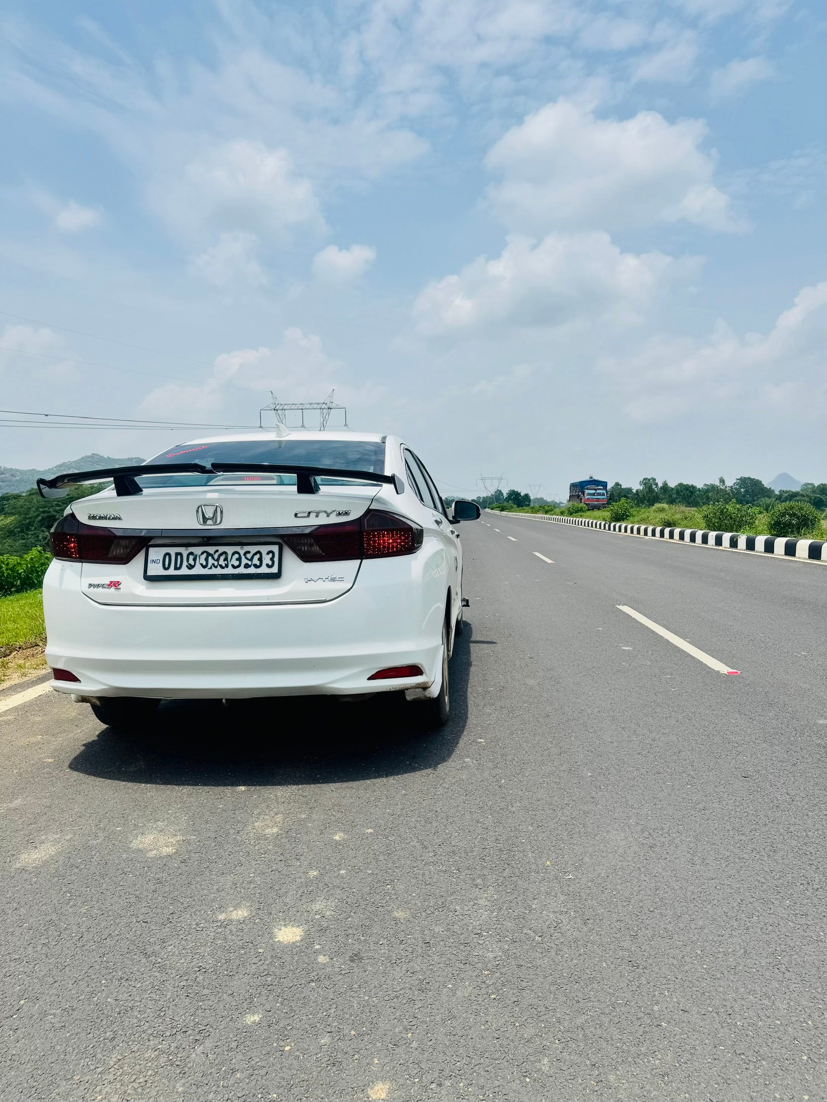 Rear view of a Honda City on an open highway