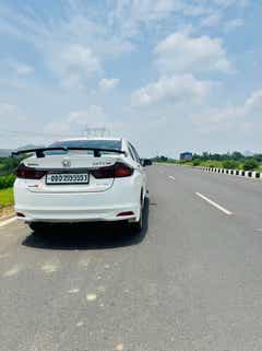 Rear view of a Honda City on an open highway