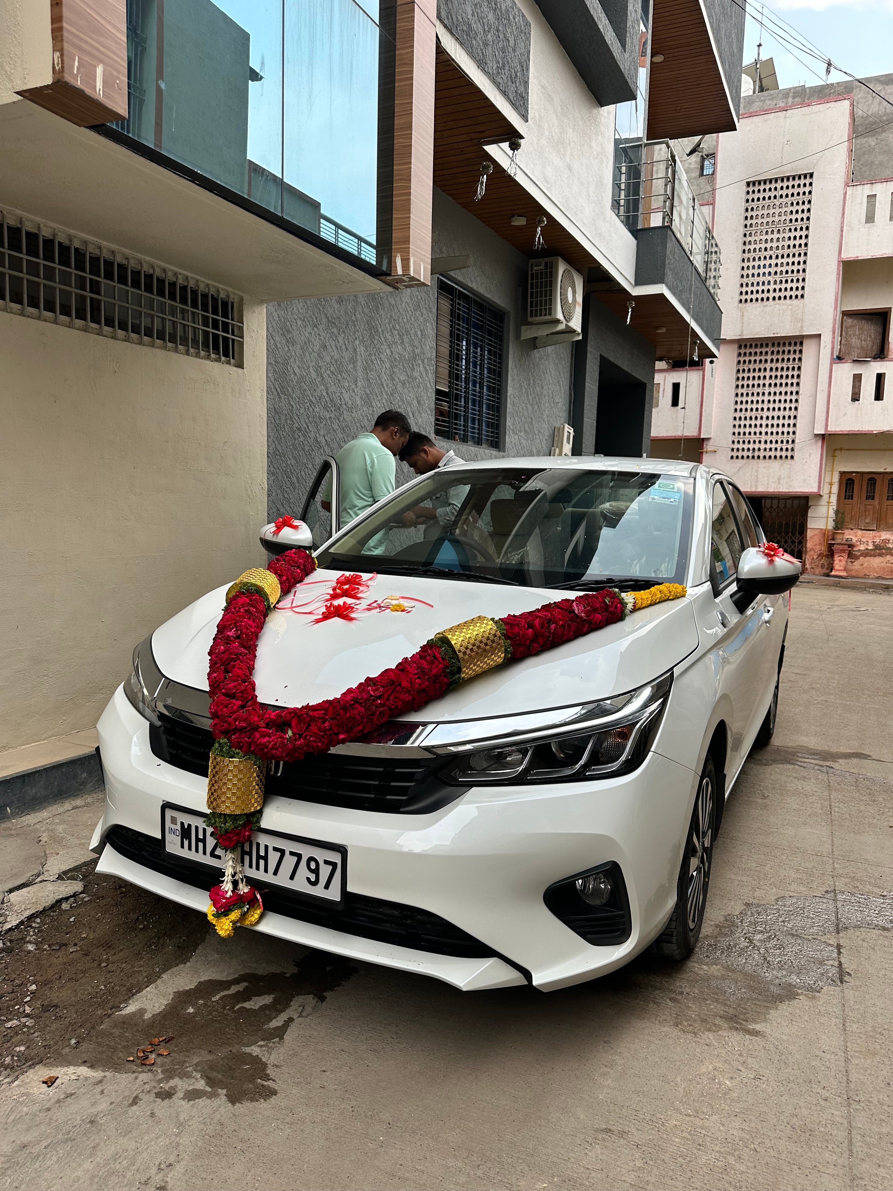 Front view of a Honda City decorated with garland in urban street