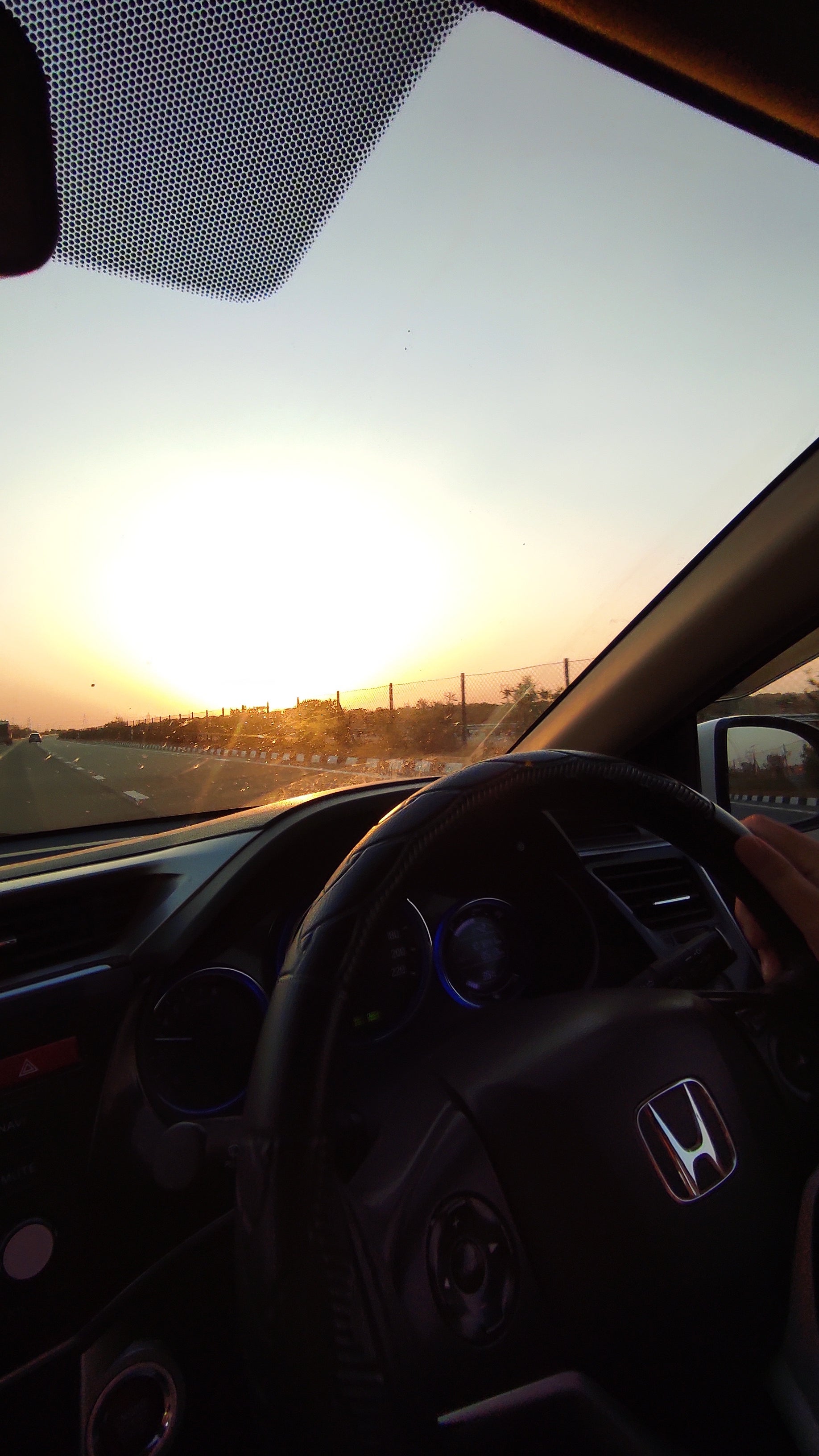 Interior dashboard and steering wheel of a Honda City during sunset