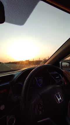 Interior dashboard and steering wheel of a Honda City during sunset