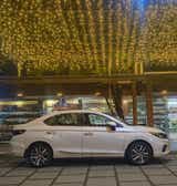 side view of a Honda City parked at night under string lights