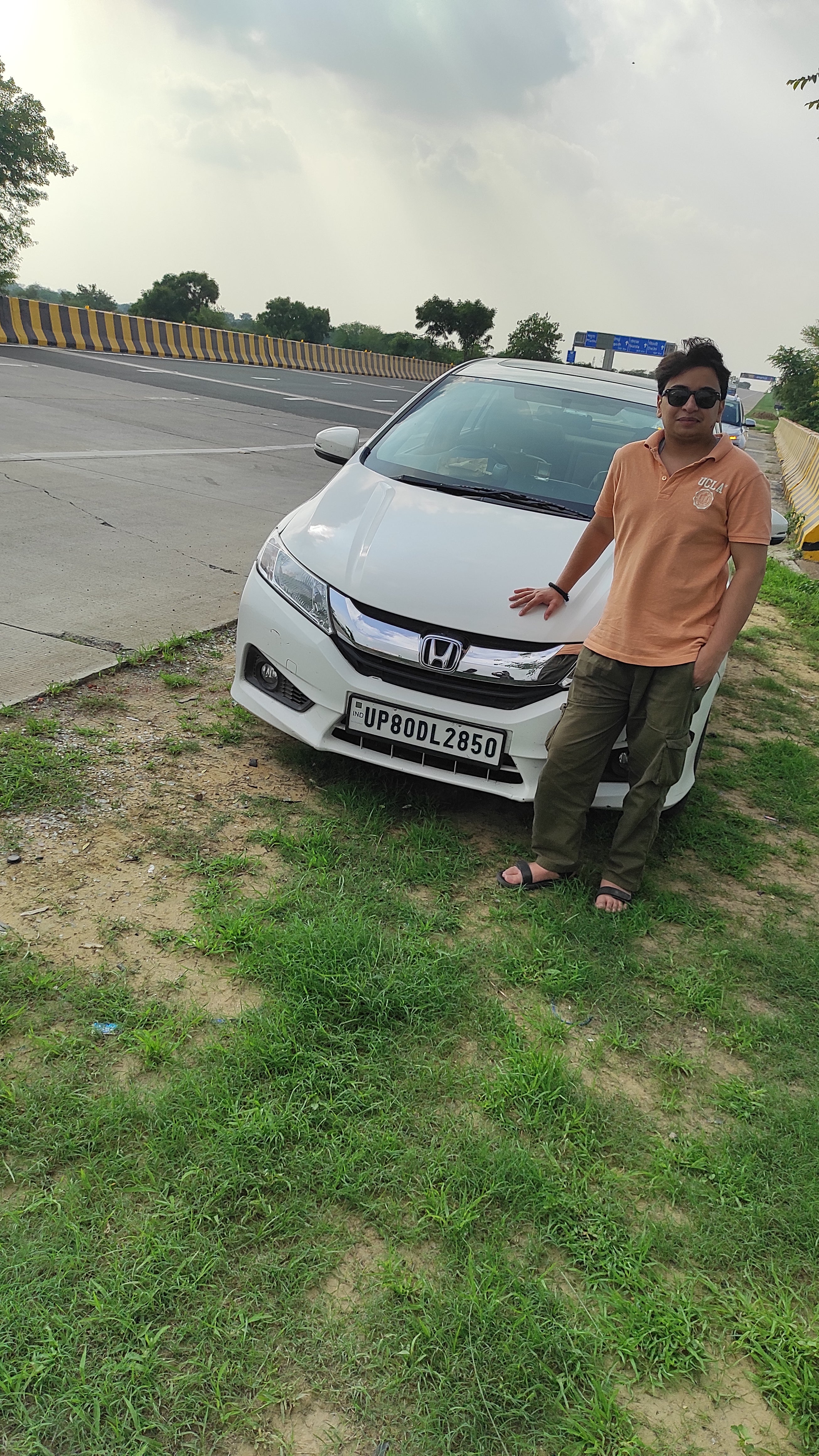 Front view of a Honda City near a highway