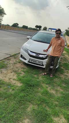 Front view of a Honda City near a highway