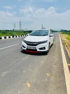 front three-quarter view of a Honda City on a highway