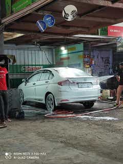 rear three-quarter view of a Honda City getting washed at a service center