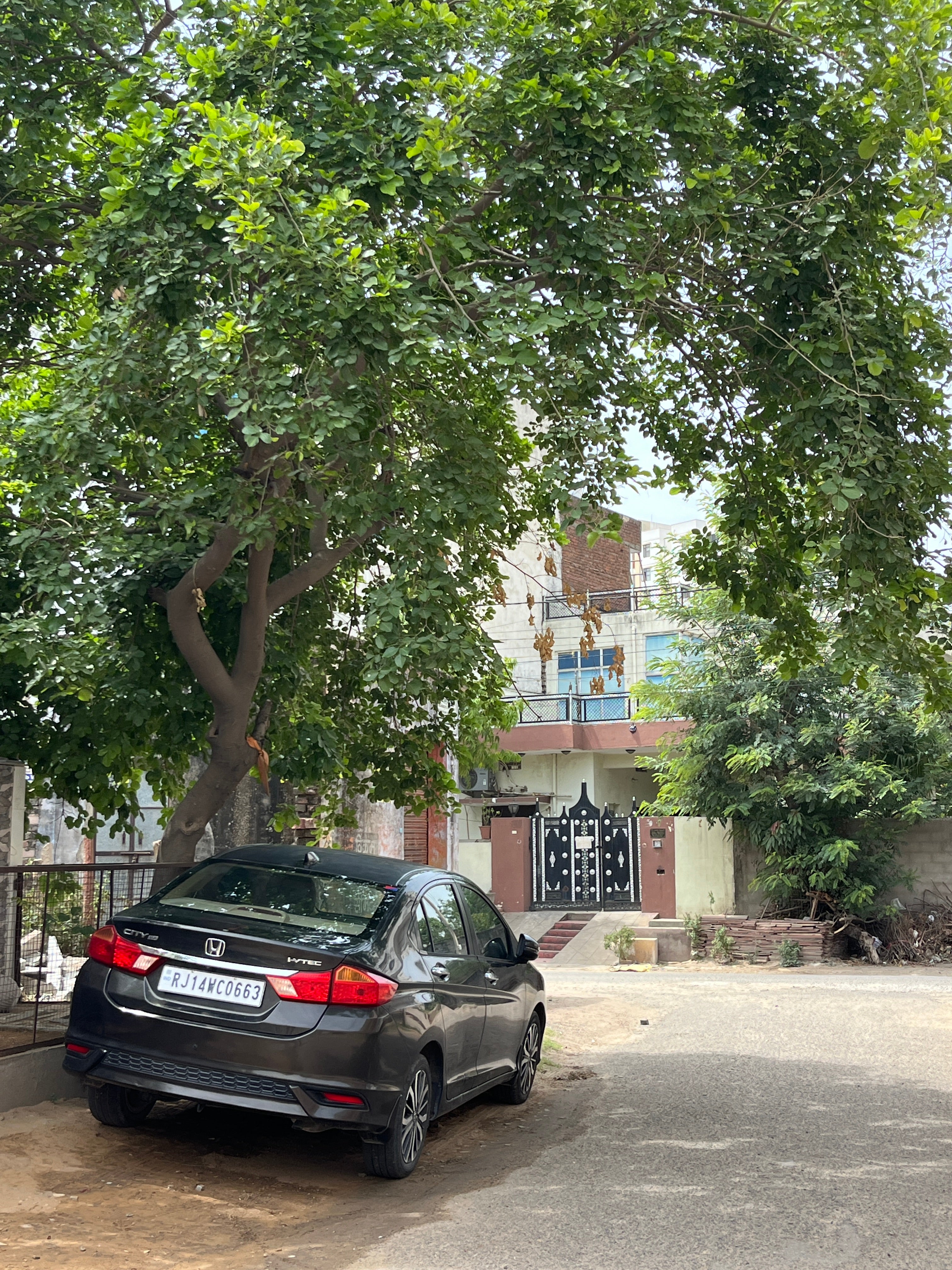 Rear three-quarter view of a Honda City parked on a residential street
