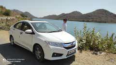 front three-quarter view of a Honda City near a riverbank