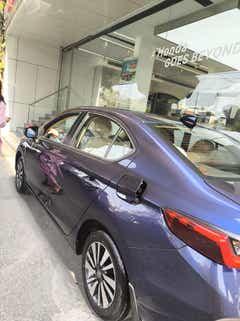 rear three-quarter view of a Honda City outside a showroom