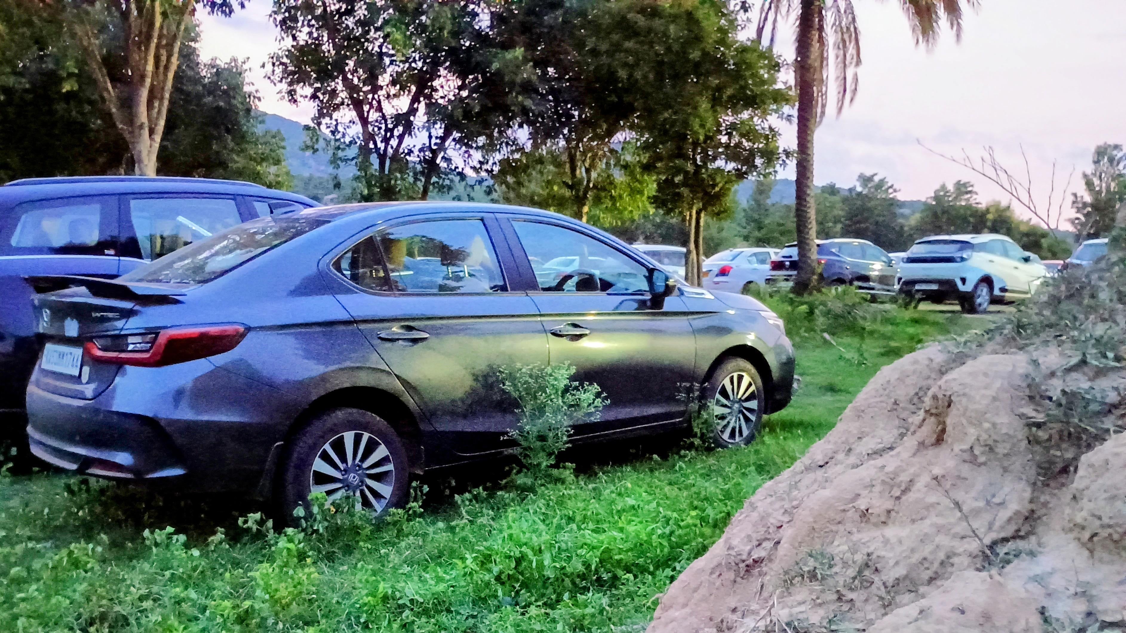 side view of a Honda City sedan parked on grass