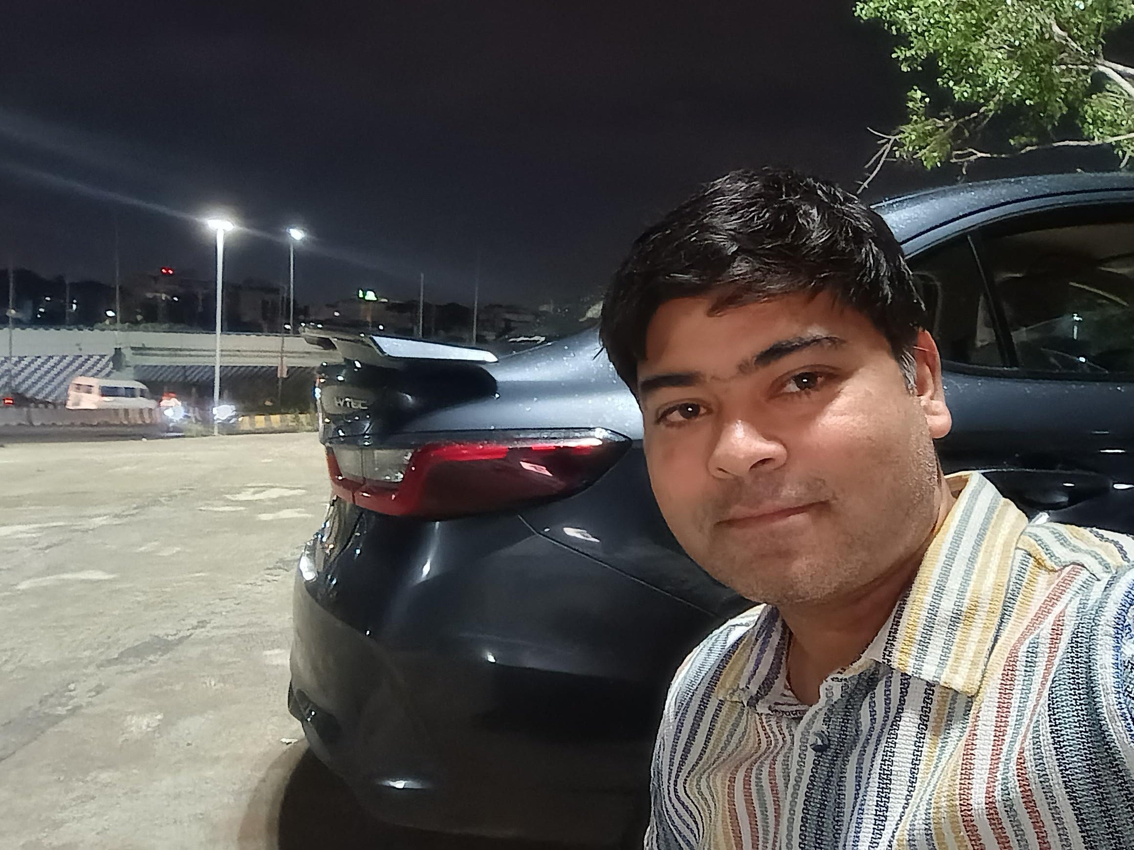 Rear view of a Honda City near a road at night