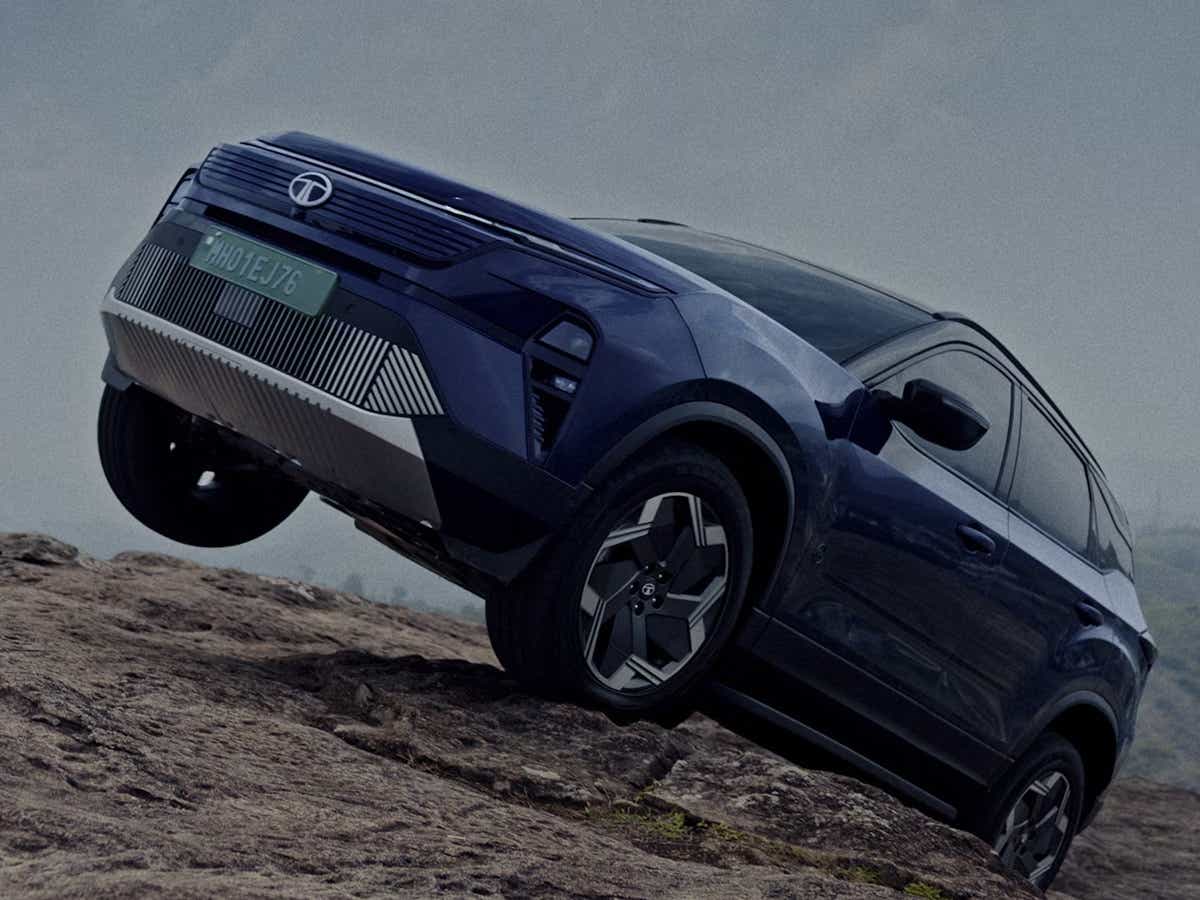 Front three-quarter view of a Tata Harrier EV climbing a rocky slope