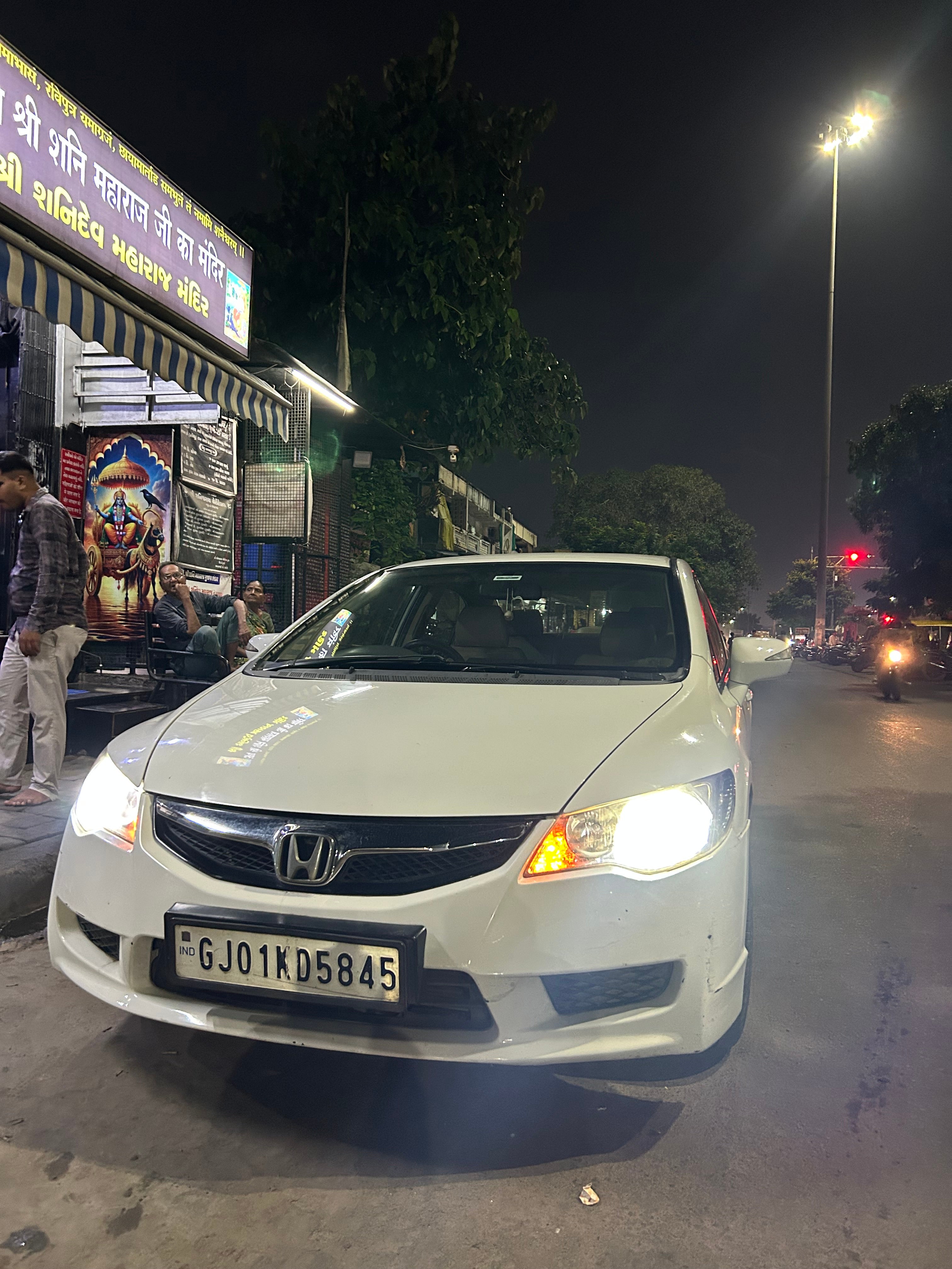 Front view of a Honda City parked at night on a city street