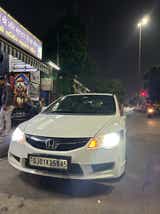 Front view of a Honda City parked at night on a city street
