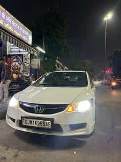 Front view of a Honda City parked at night on a city street