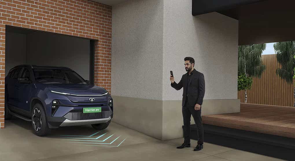Front view of a Tata Harrier EV emerging from a garage