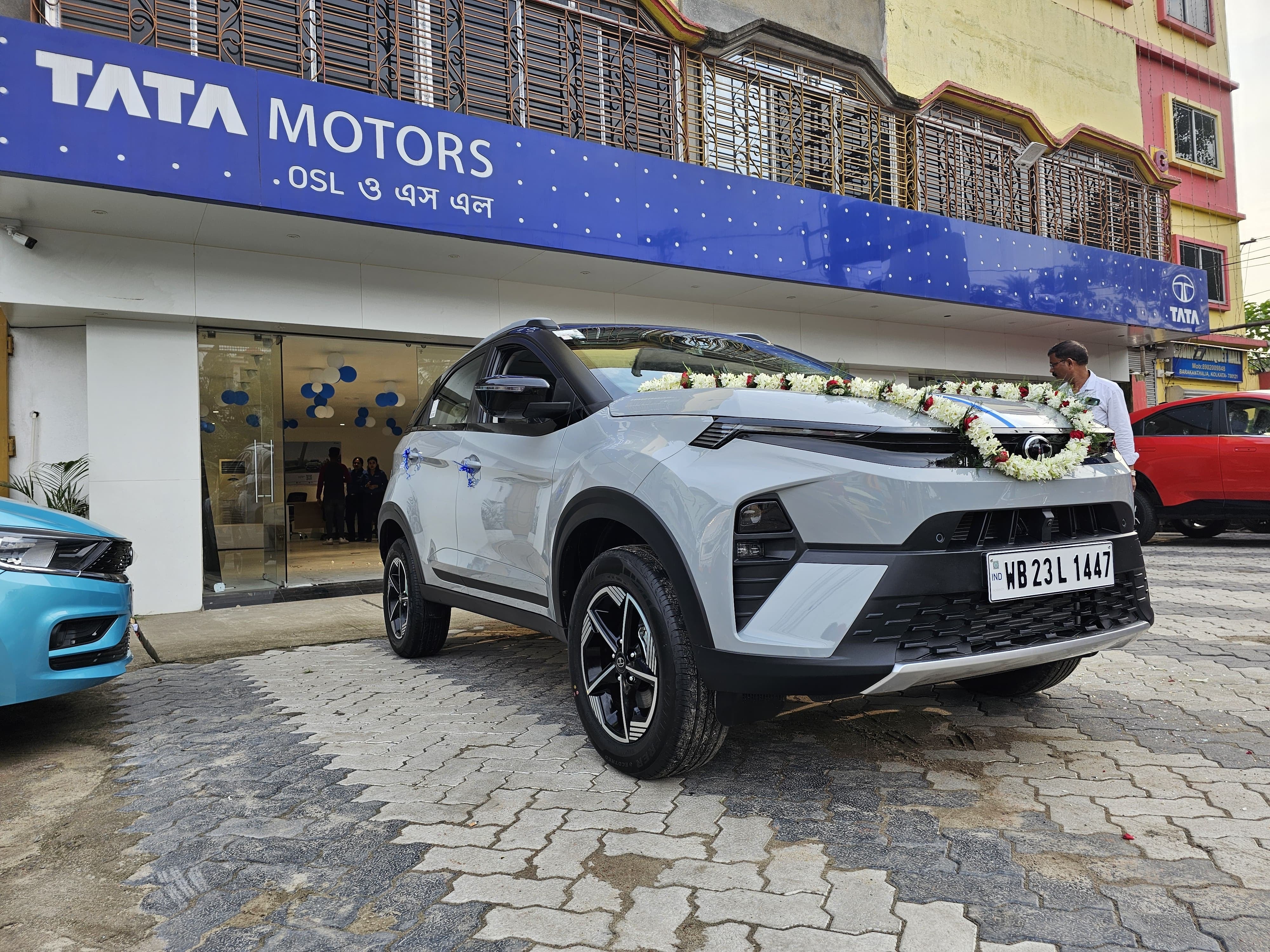 front three-quarter view of a Pure Grey Tata Nexon outside Tata showroom