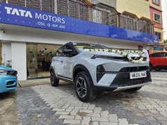 front three-quarter view of a Pure Grey Tata Nexon outside Tata showroom