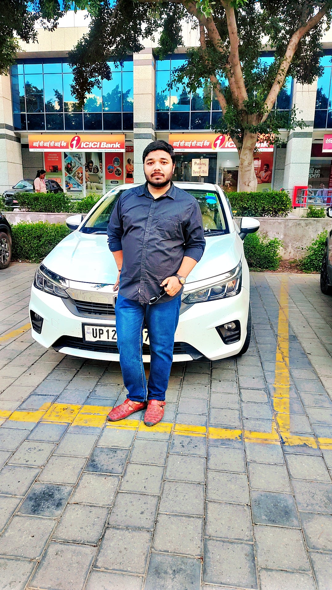 Front view of a Honda City in front of a bank