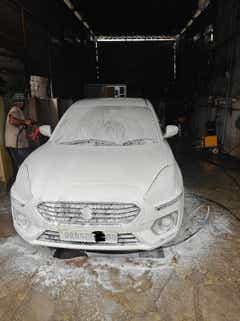 front view of a Maruti Suzuki Dzire 2018-2023 being washed
