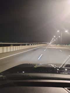 dashboard and hood view from a Honda City at night on a bridge