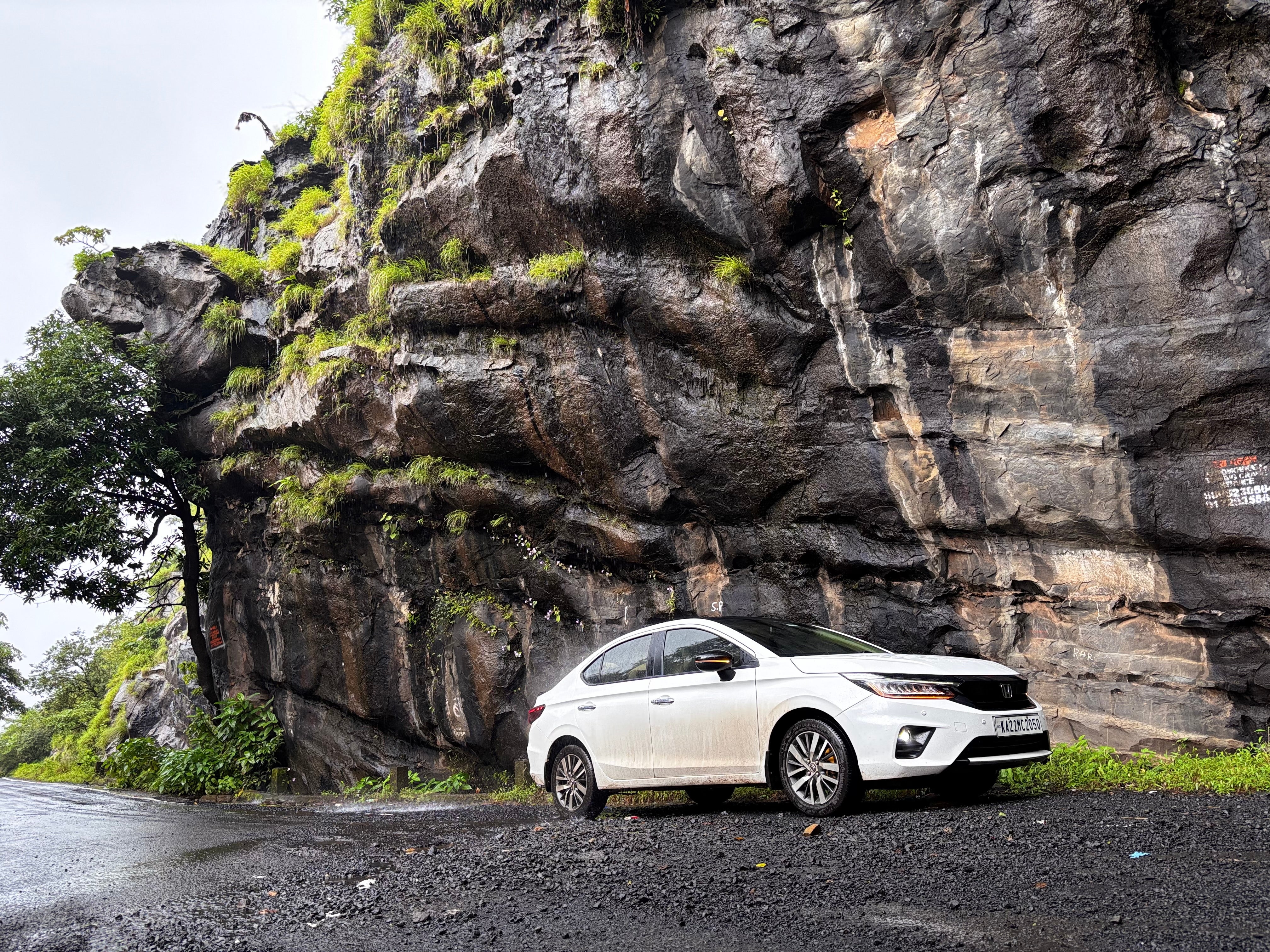 front and side view of a Honda City near a rocky hillside