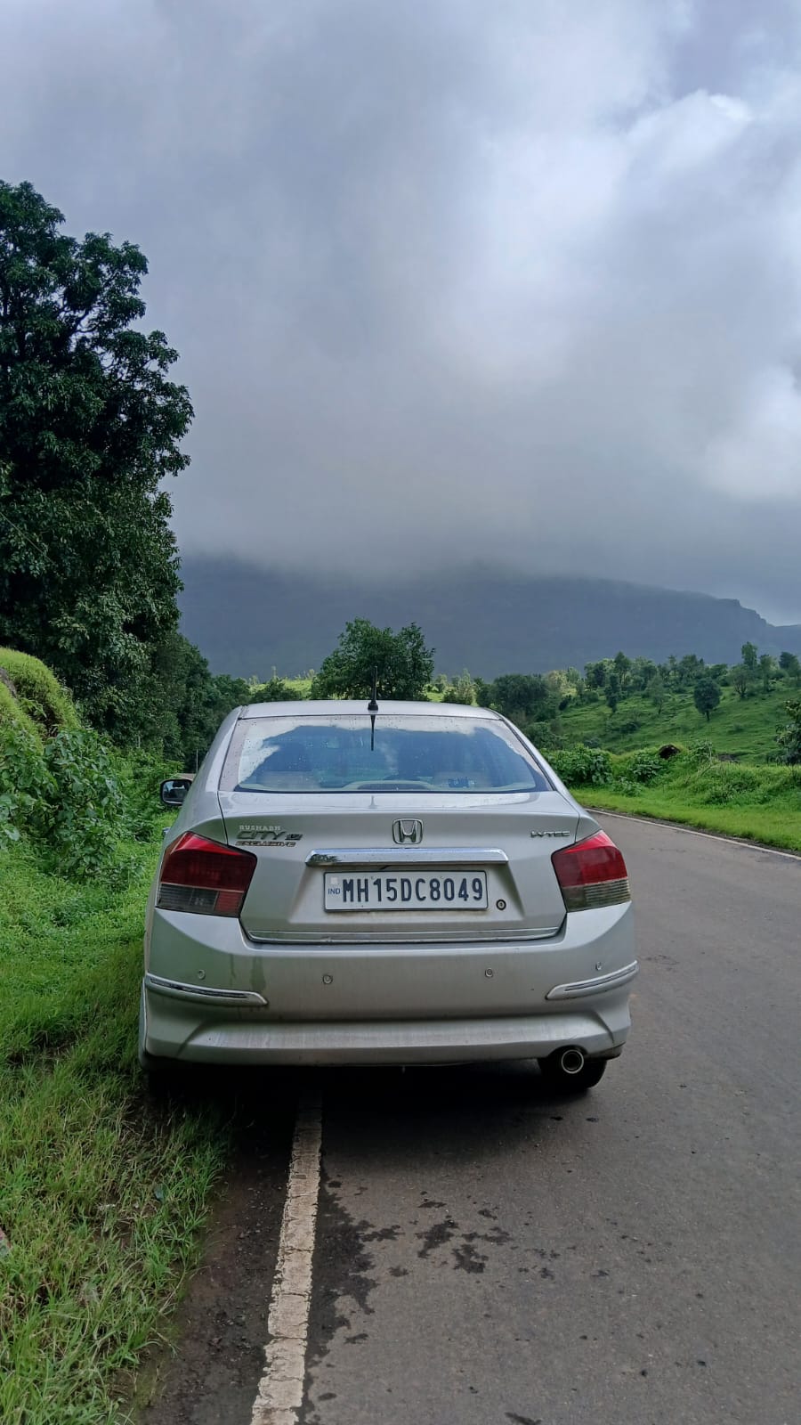rear view of a Honda City on a scenic road