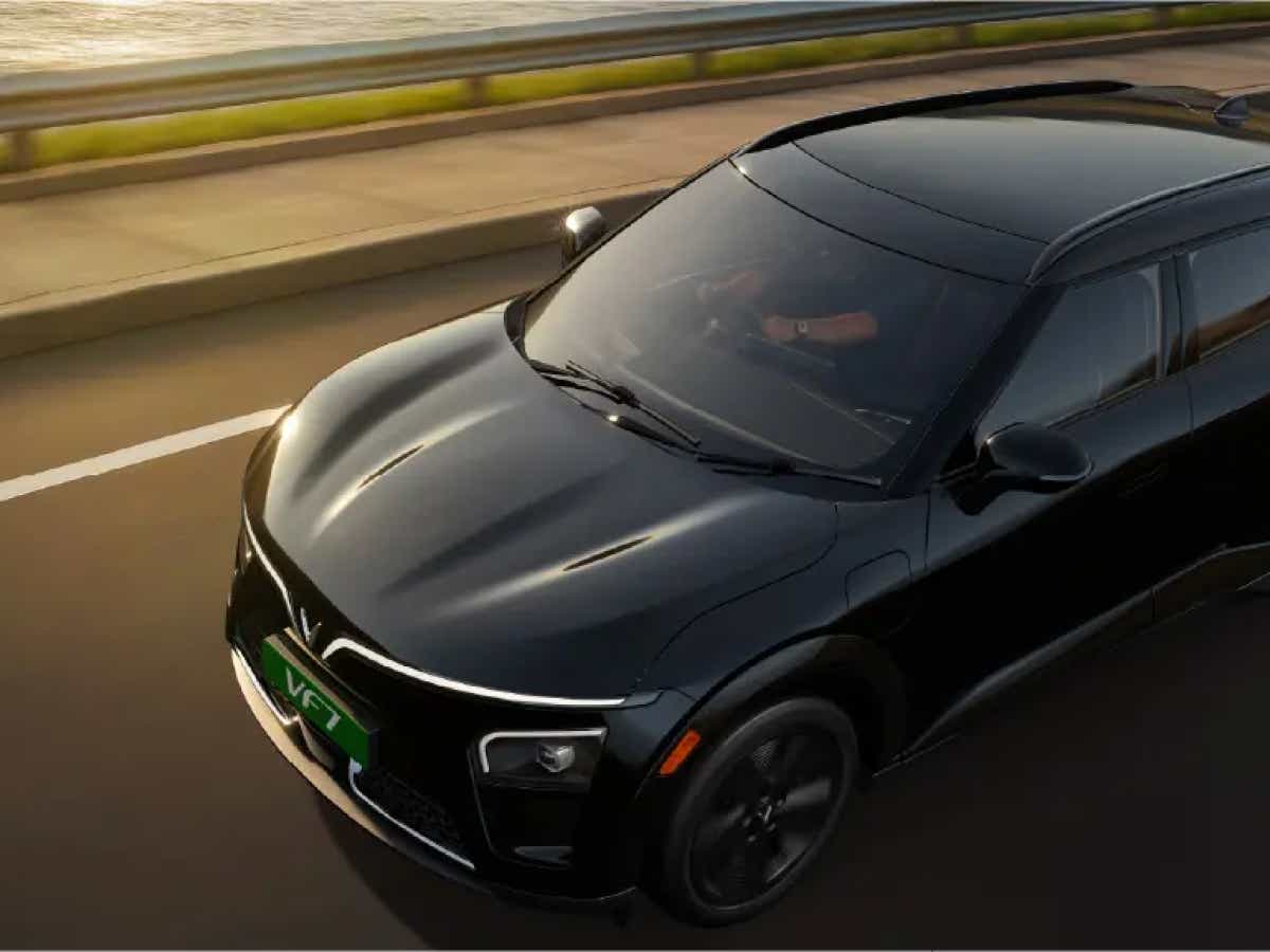 front and side view of a Jet Black Vinfast VF7 moving on a road