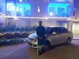 Front three-quarter view of a Maruti Suzuki Dzire parked outside a building at night