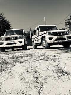 Front view of two Mahindra Bolero vehicles parked outdoors