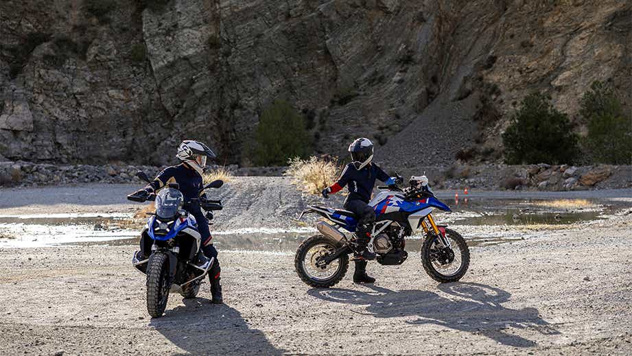 Outdoor view of a bmw f 450 gs with two riders near rocky terrain