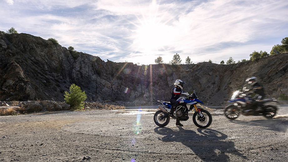 Side view of a BMW F 450 GS with rider in a mountainous terrain