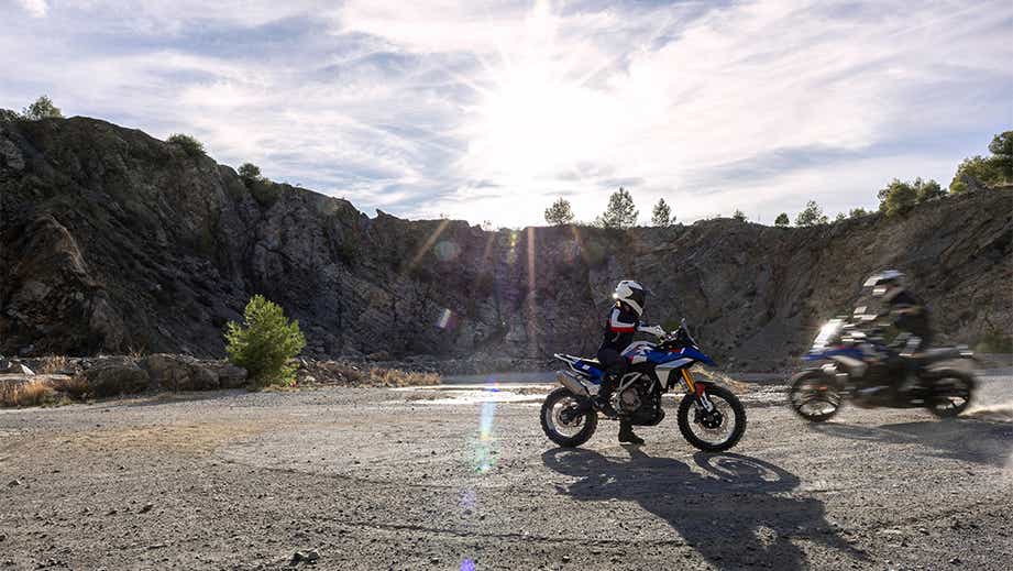 Side view of a BMW F 450 GS with rider in a mountainous terrain