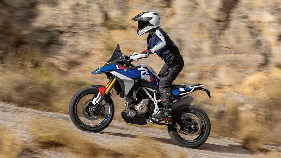 Side view of a BMW F 450 GS being ridden on a rocky road