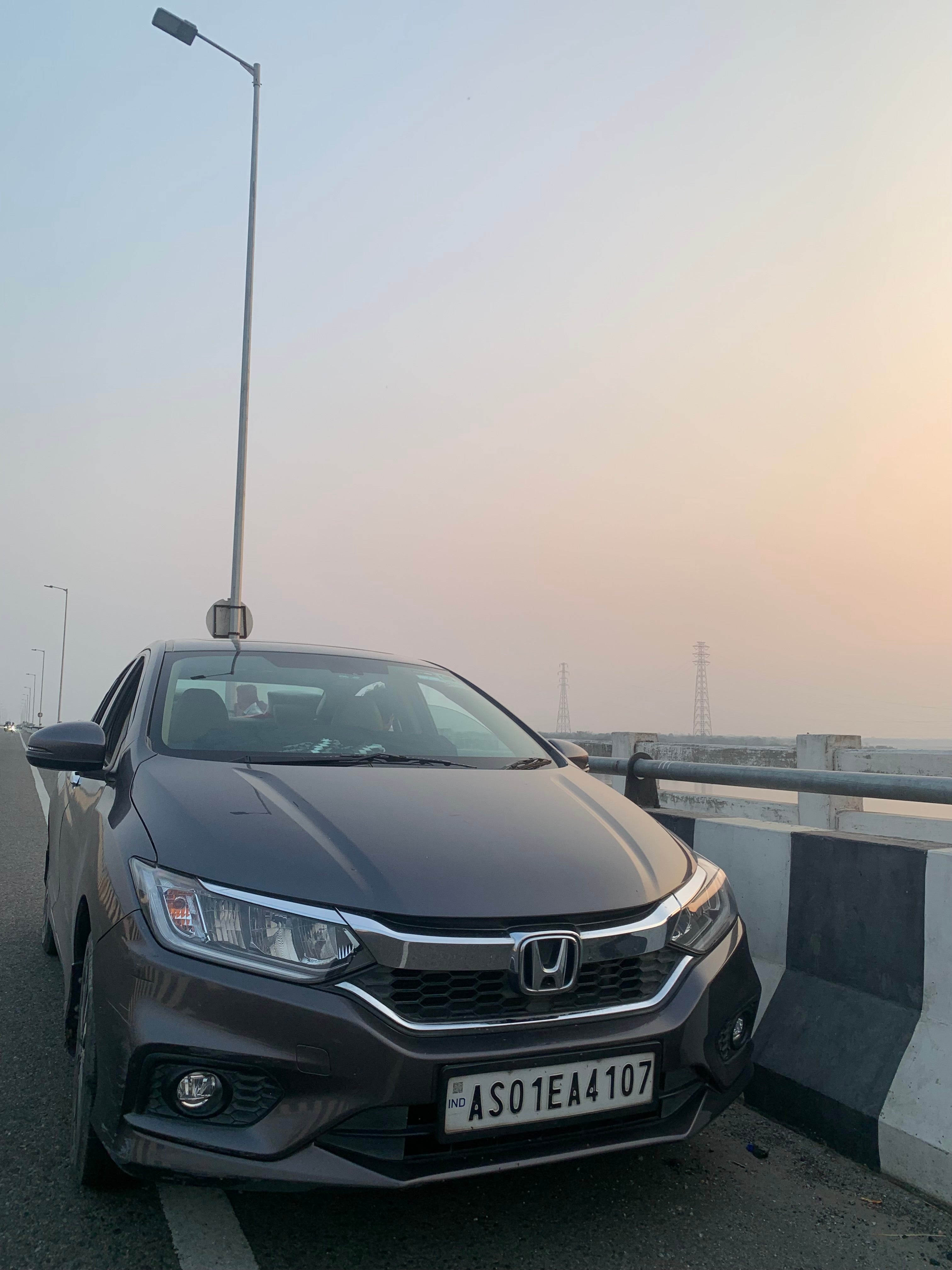 Front view of a meteoroid grey metallic Honda City on a highway