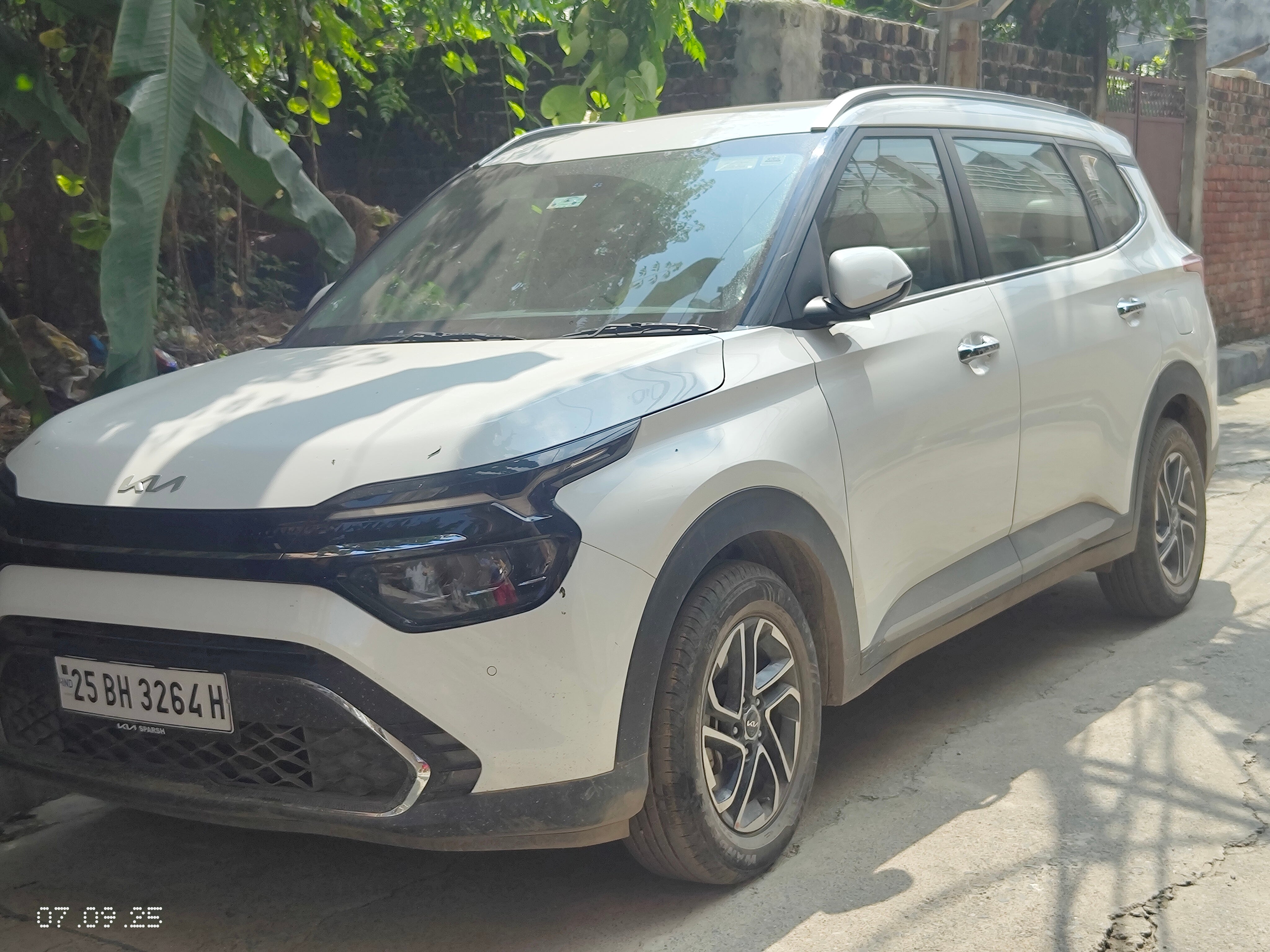 Front three-quarter of a glacier white pearl Kia Carens