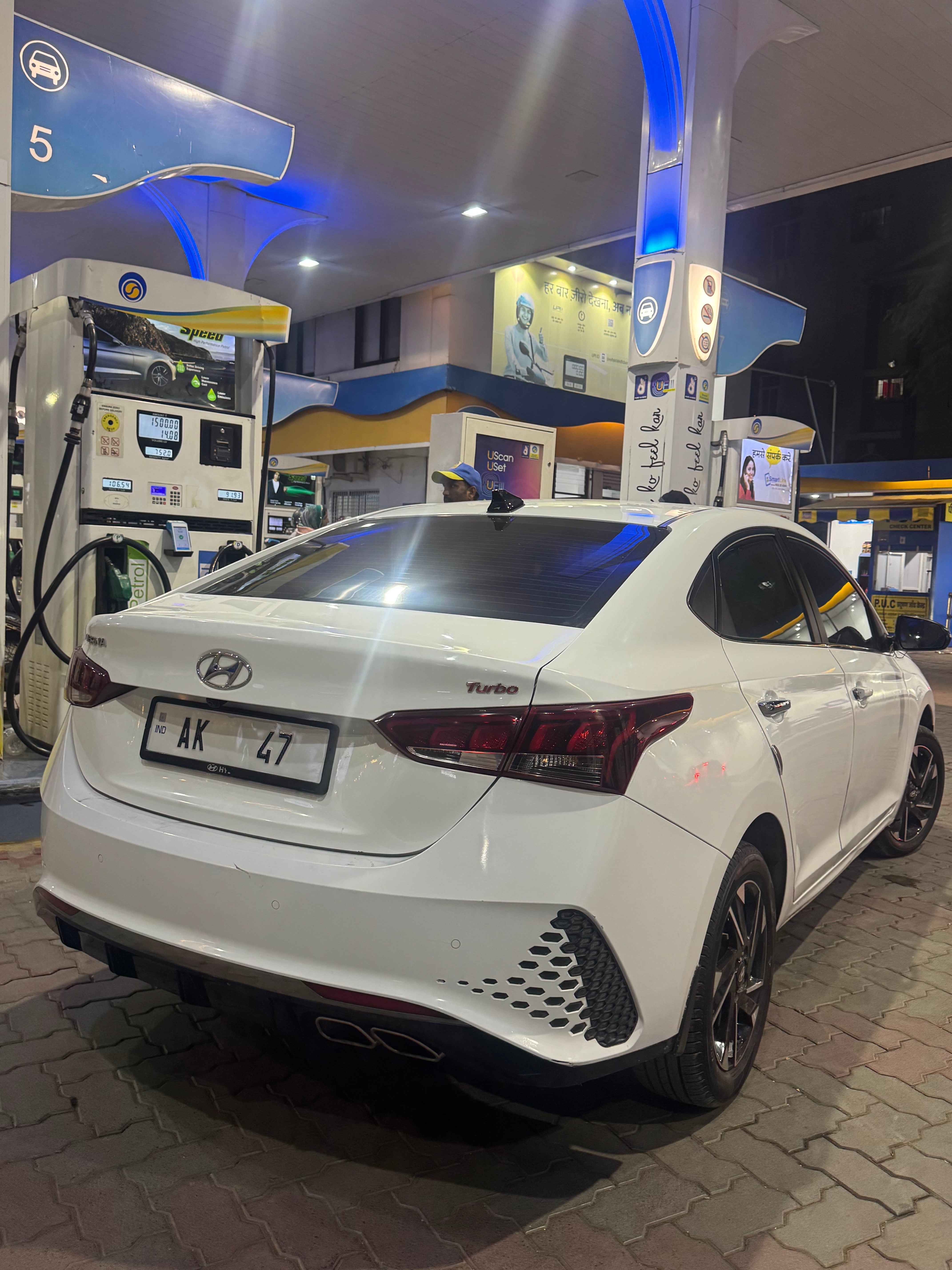 Rear three-quarter of a Hyundai Verna at a fuel station