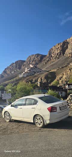 rear three-quarter of a Honda City near mountain village