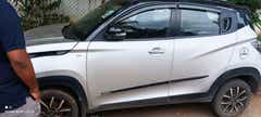 Side view of a dazzling silver with metallic black Mahindra KUV 100 NXT