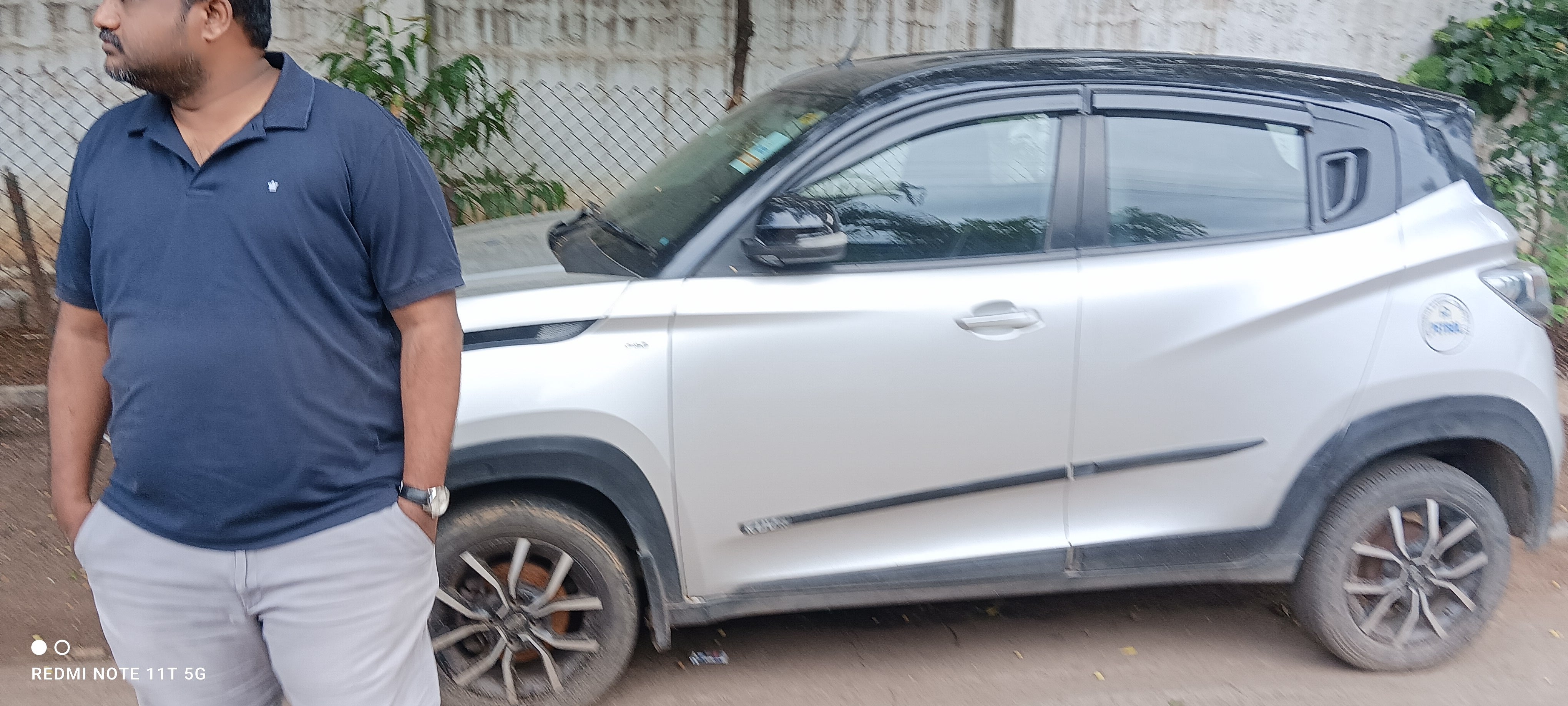 Side view of a dazzling silver with metallic black Mahindra KUV 100 NXT