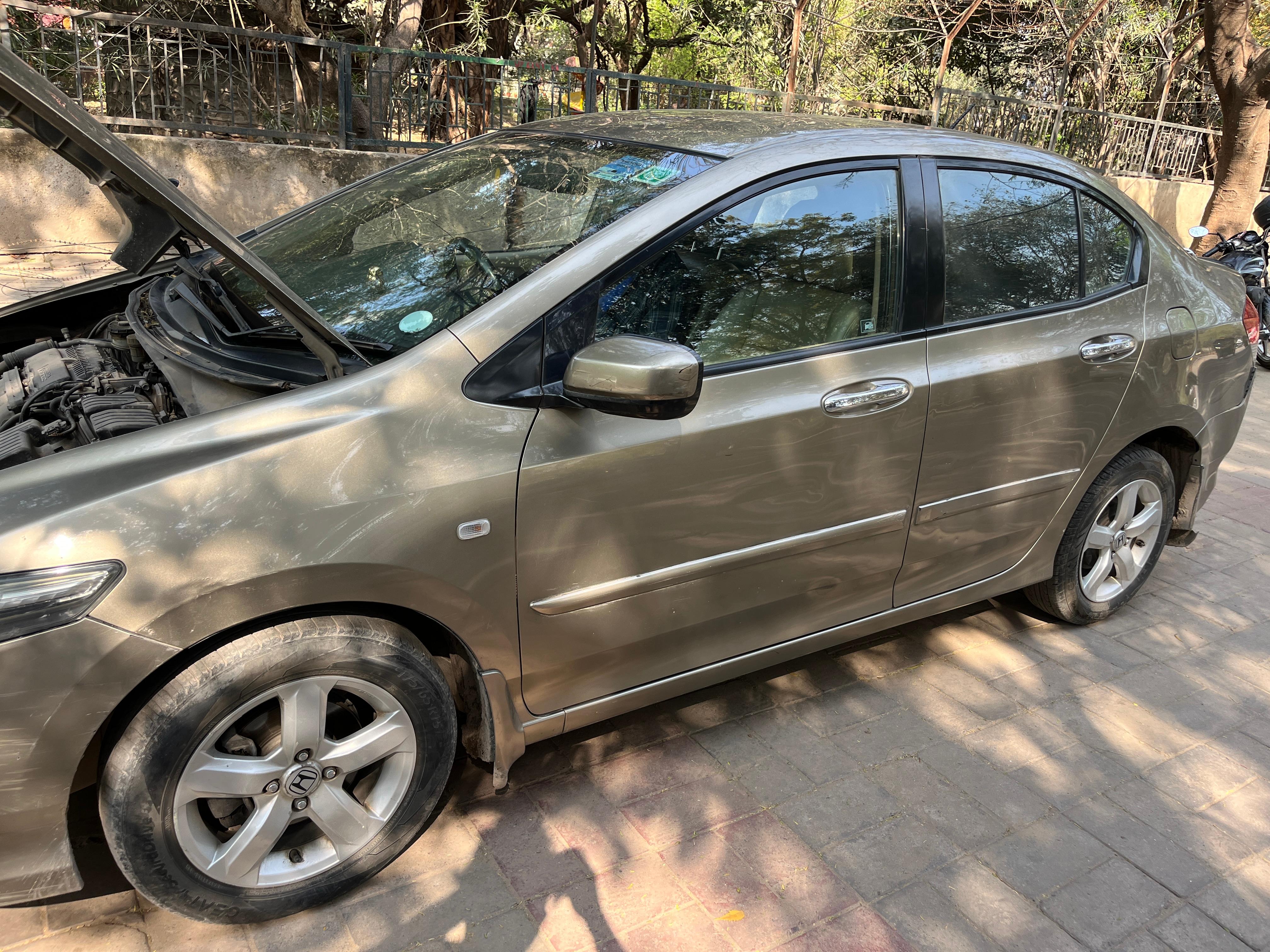 Side view of a Honda City with hood open